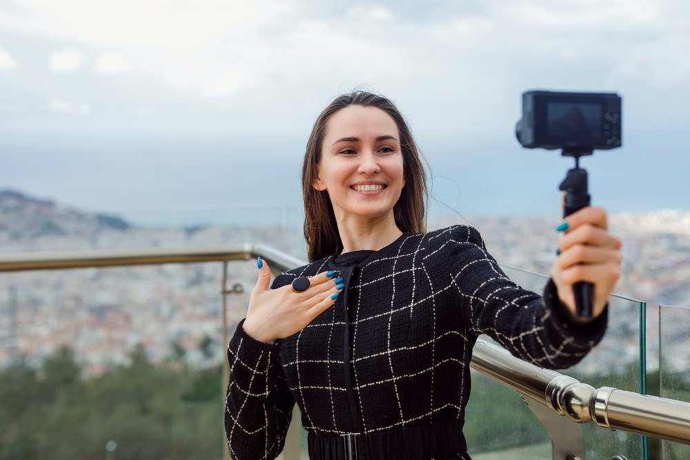 Persona grabándose un video con vista a la ciudad