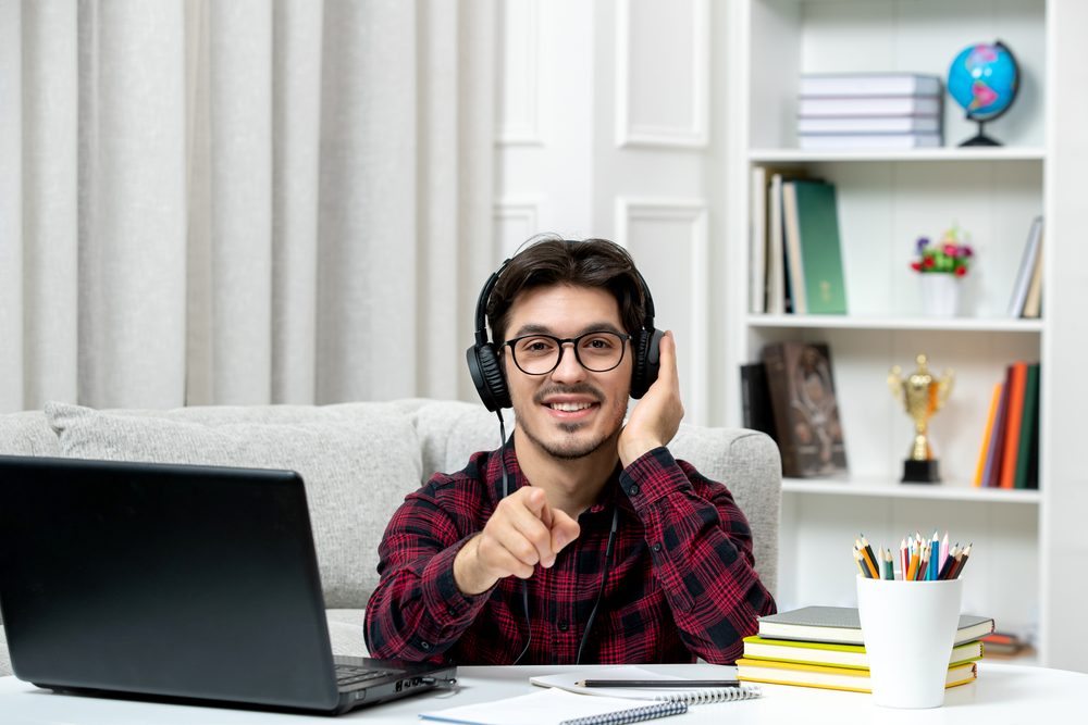 Estudiante sonriente en una videollamada con su laptop